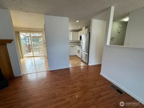 a view of a hallway with wooden floor and a living room