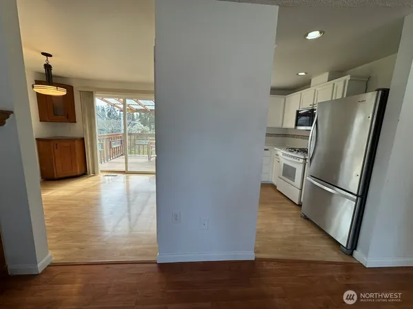 a view of a kitchen with wooden floor and electronic appliances