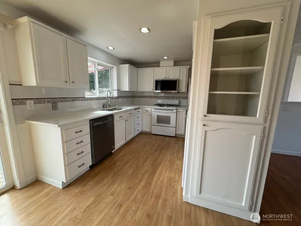 a kitchen with cabinets oven and a sink