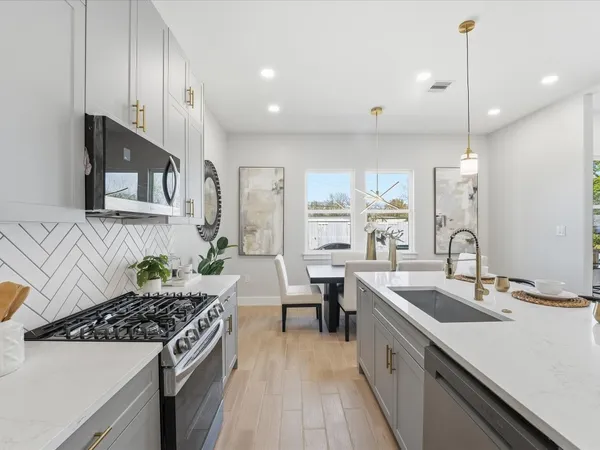 a kitchen with stainless steel appliances a sink stove and cabinets