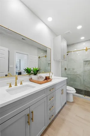 a bathroom with a sink a toilet and shower