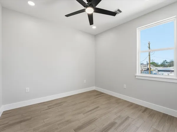 a view of wooden floor and a chandelier fan in a room