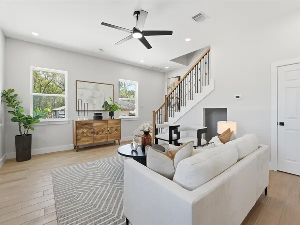 a living room with furniture kitchen view and a potted plant