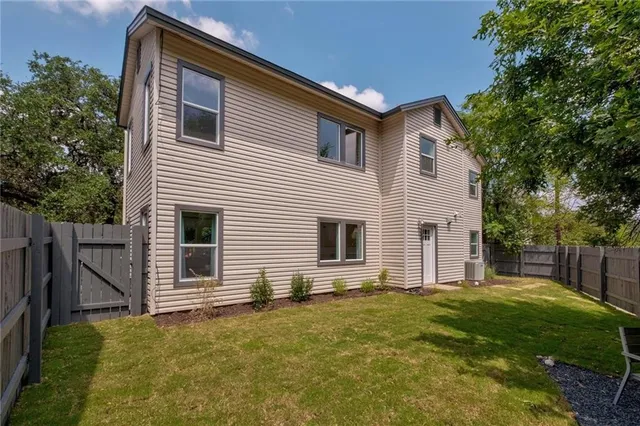 a backyard of a house with potted plants and large tree