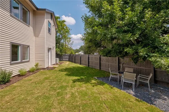 a backyard of a house with table and chairs