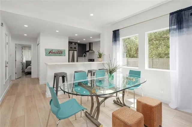 a living room with furniture a dining table and a large window