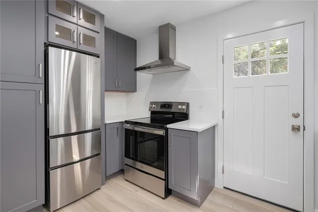 a kitchen with stainless steel appliances granite countertop a refrigerator a stove a microwave and a refrigerator