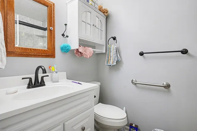 a bathroom with a sink mirror vanity and toilet