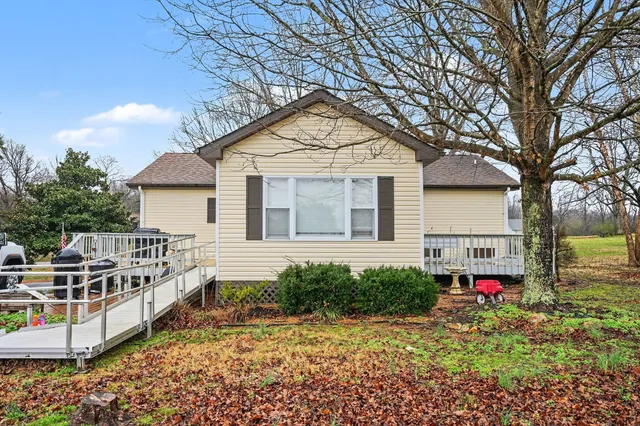 a front view of house with sign board and yard