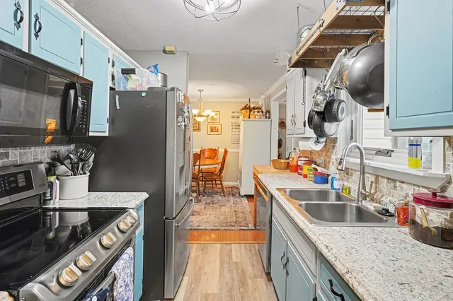 a kitchen with stainless steel appliances granite countertop a sink stove and refrigerator