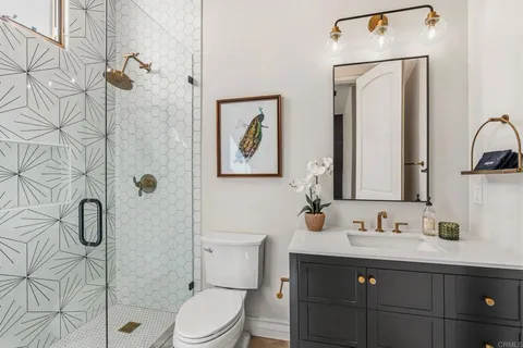 a bathroom with a sink vanity mirror and toilet