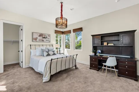 a bedroom with a bed and a chandelier