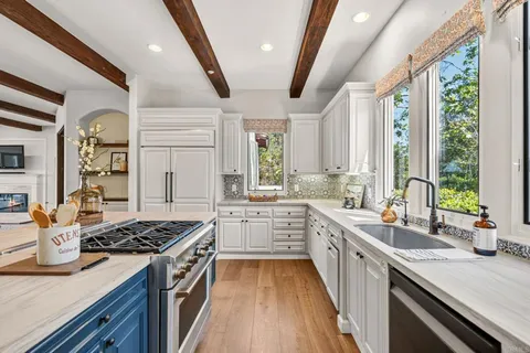 a kitchen with stainless steel appliances a sink stove and cabinets