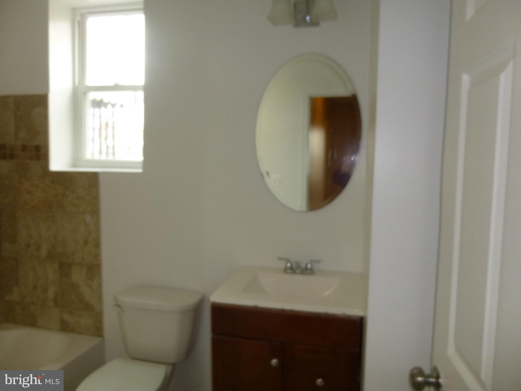 2140 Presstman Street Baltimore, MD 21217 - Photo 11 of 11 a bathroom with a toilet a sink and mirror
