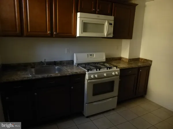 a kitchen with stainless steel appliances granite countertop a stove a microwave and a sink