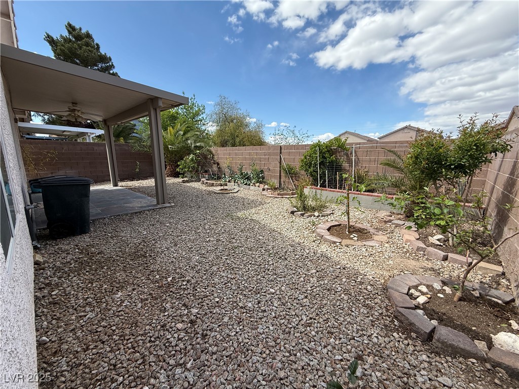 7062 Russell Ranch Avenue Las Vegas, NV 89113 - Photo 14 of 32 View of yard with a fenced backyard, a patio, and a ceiling fan