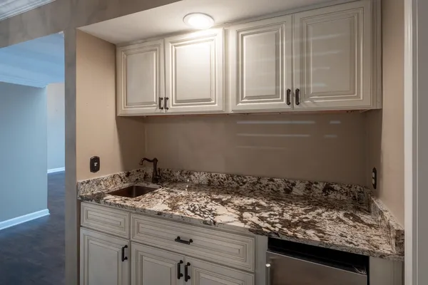 a kitchen with granite countertop white cabinets and a stove