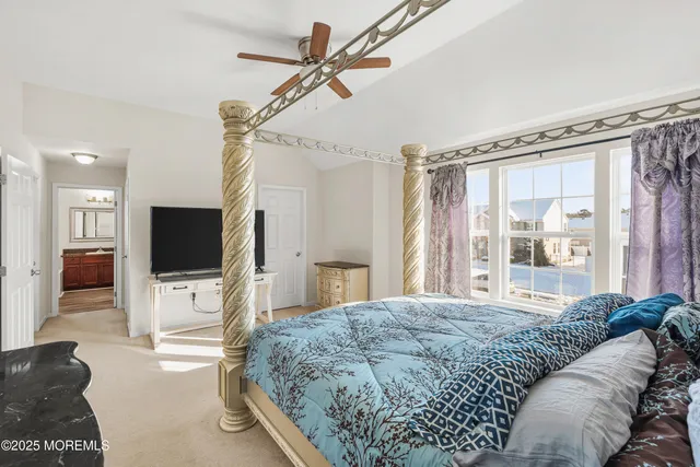a bedroom with a bed and a flat tv screen on dresser