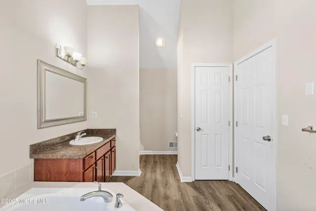 a bathroom with a granite countertop toilet a sink and a mirror