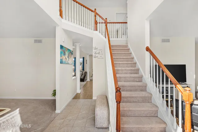 a view of staircase with lots of frames on wall and a large window