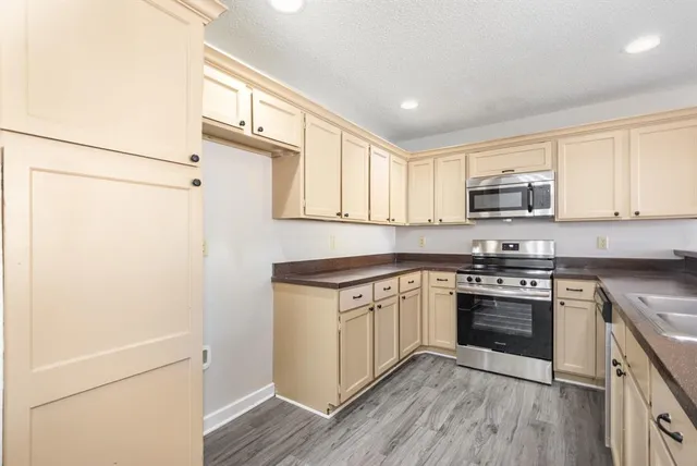 a kitchen with stainless steel appliances granite countertop a stove a sink and a refrigerator