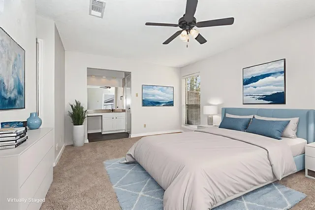 a bedroom with a large bed a flat screen tv and couches