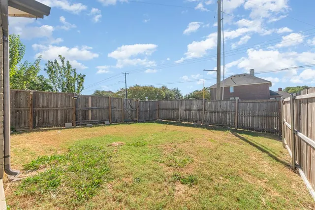 a view of backyard with iron fence