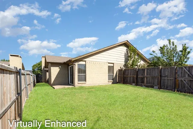 a view of a backyard with potted plants and wooden fence