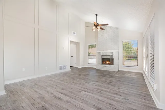 wooden floor fireplace and windows in an empty room