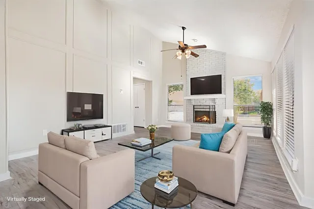 a living room with furniture a flat screen tv and a fireplace