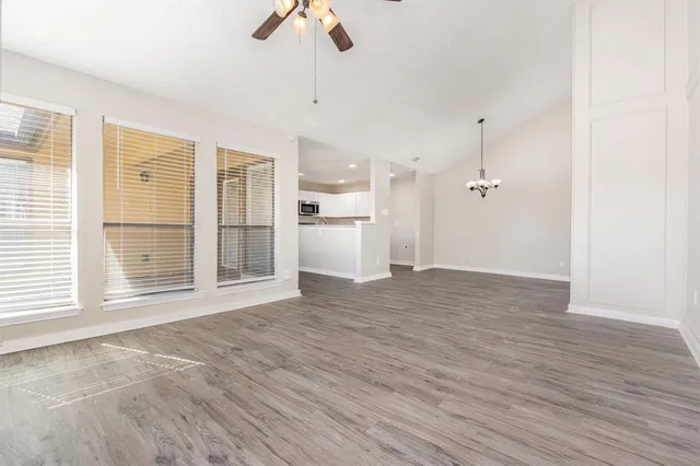 a view of empty room with wooden floor and window