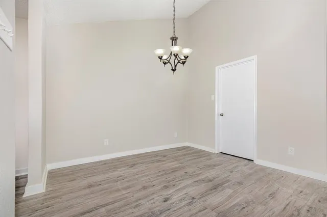 a view of a room with wooden floor and chandelier