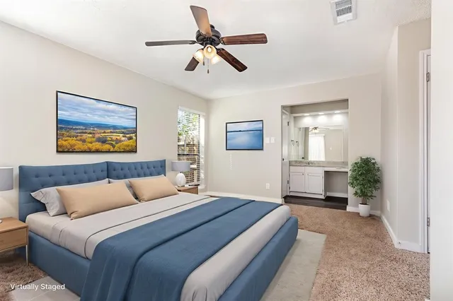 a bedroom with a bed a couch and a potted plant