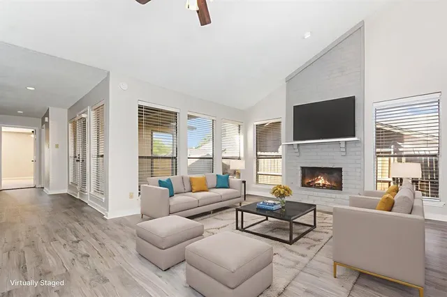 a living room with furniture a fireplace and a flat screen tv
