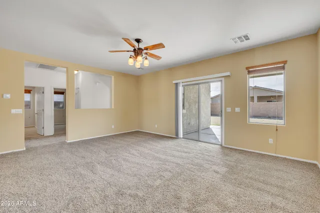 a view of a livingroom with a ceiling fan window and a kitchen