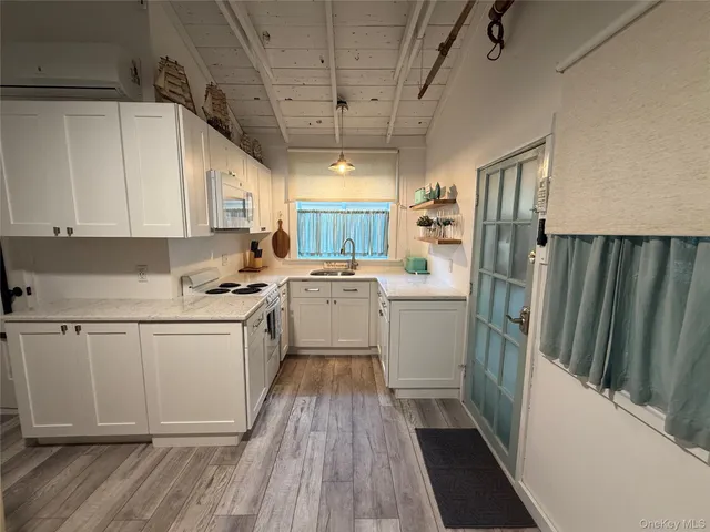 a kitchen with white cabinets a sink stove and refrigerator