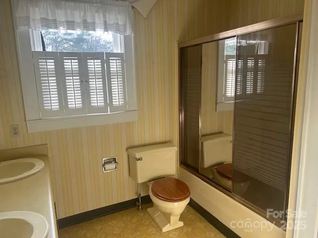 a bathroom with a toilet and a shower