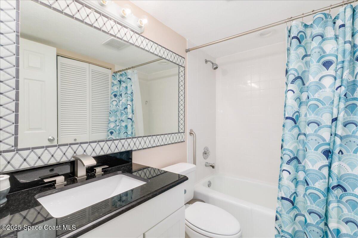 6124 River Run Drive Sebastian, FL 32958 - Photo 14 of 42 a bathroom with a granite countertop sink toilet a mirror a bathtub and shower