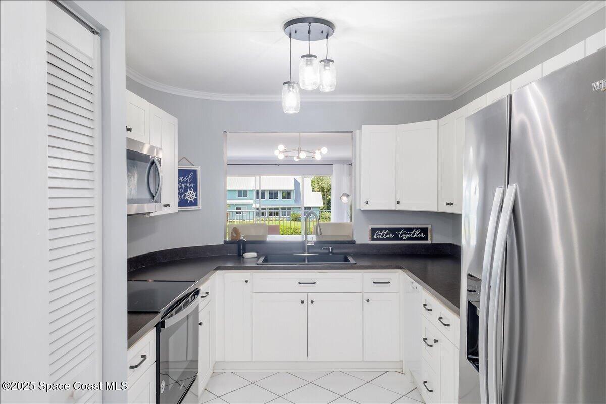 6124 River Run Drive Sebastian, FL 32958 - Photo 10 of 42 a kitchen with stainless steel appliances a sink a stove a refrigerator cabinets and a window