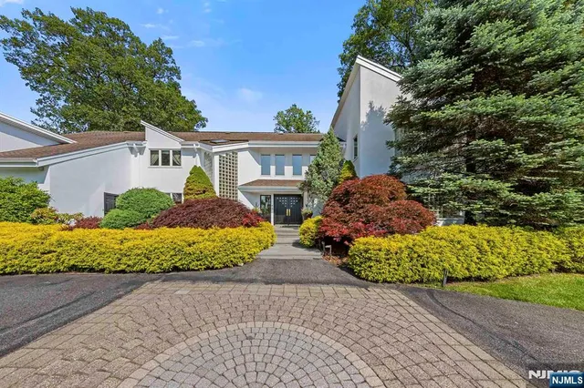 a front view of a house with a yard and a garden