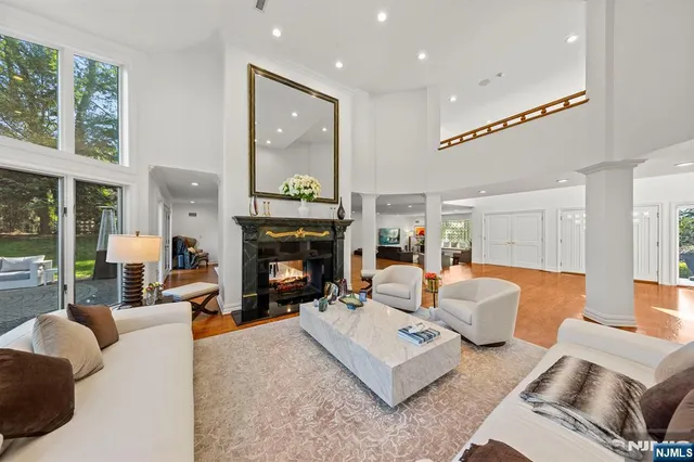 a living room with furniture a fireplace and a floor to ceiling window