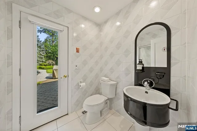 a bathroom with a toilet sink a mirror and shower