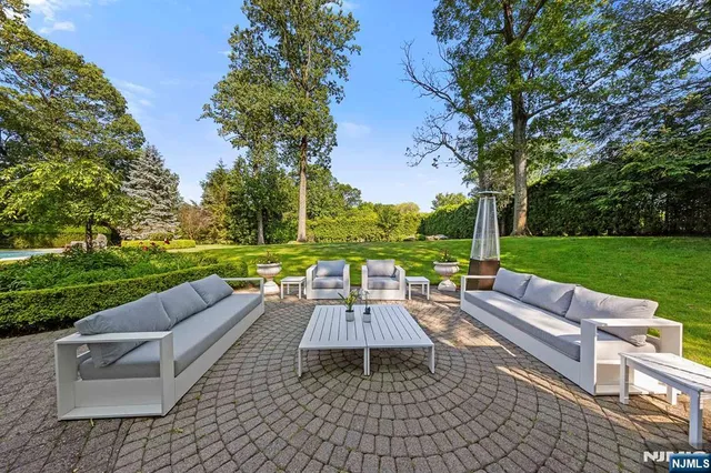 a view of a patio with a dining table and chairs with a couches near a yard