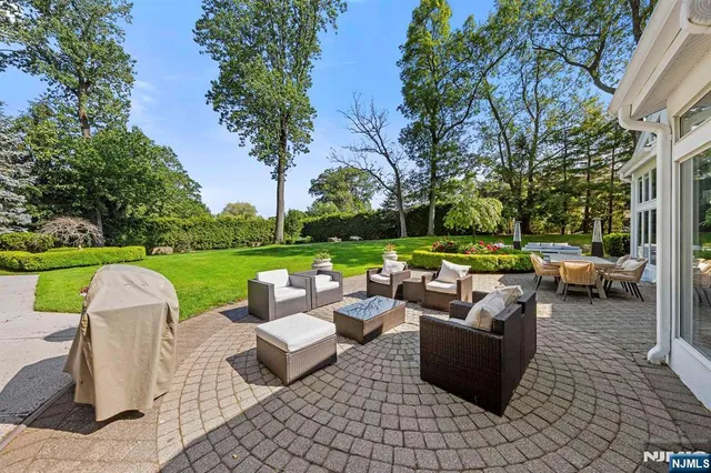 a view of a patio with couches potted plants and a big yard