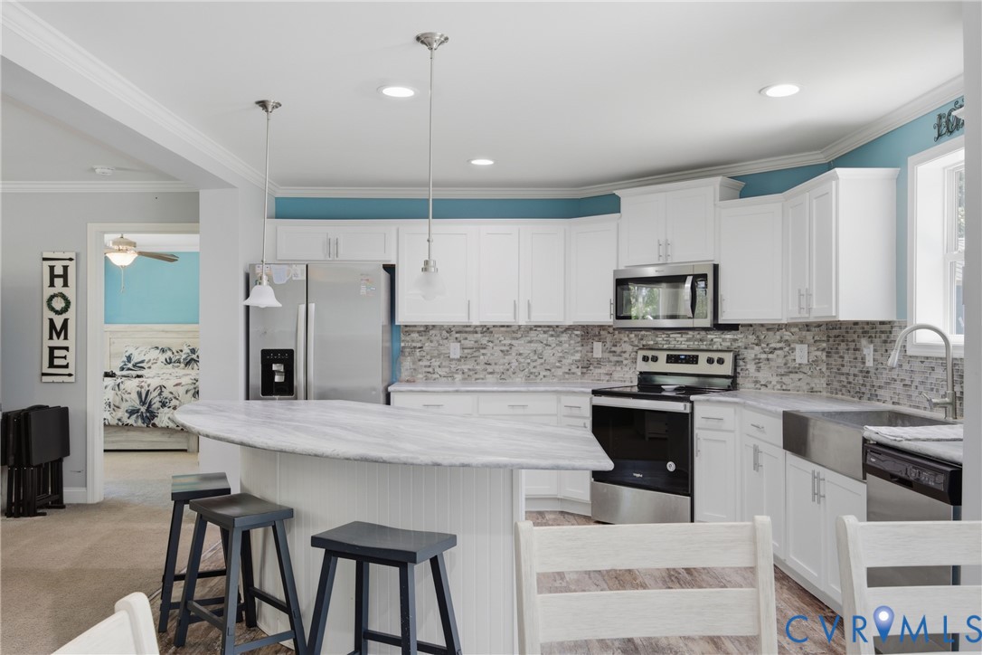 93 Faraway Road Saluda, VA 23149 - Photo 10 of 58 a kitchen with kitchen island granite countertop a stove top oven a sink dishwasher a dining table and chairs with wooden floor