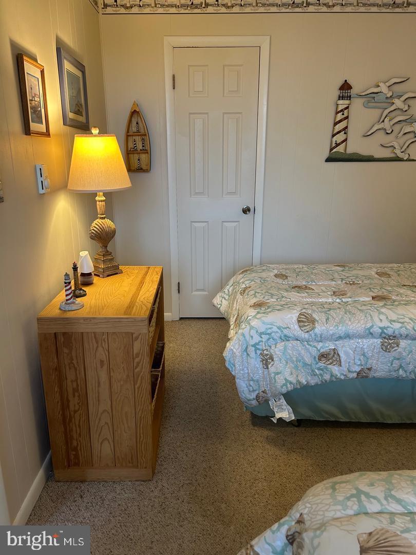 745 Mooring Road, Unit 103 Ocean City, MD 21842 - Photo 12 of 14 a bedroom with a bed and a lamp