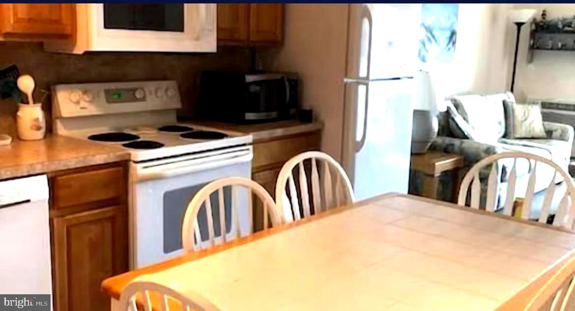 745 Mooring Road, Unit 103 Ocean City, MD 21842 - Photo 4 of 14 a view of a kitchen with stainless steel appliances granite countertop a stove top oven a sink and dishwasher