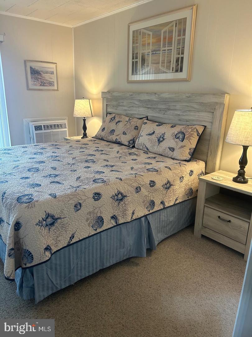 745 Mooring Road, Unit 103 Ocean City, MD 21842 - Photo 6 of 14 a bedroom with a bed and a night stand
