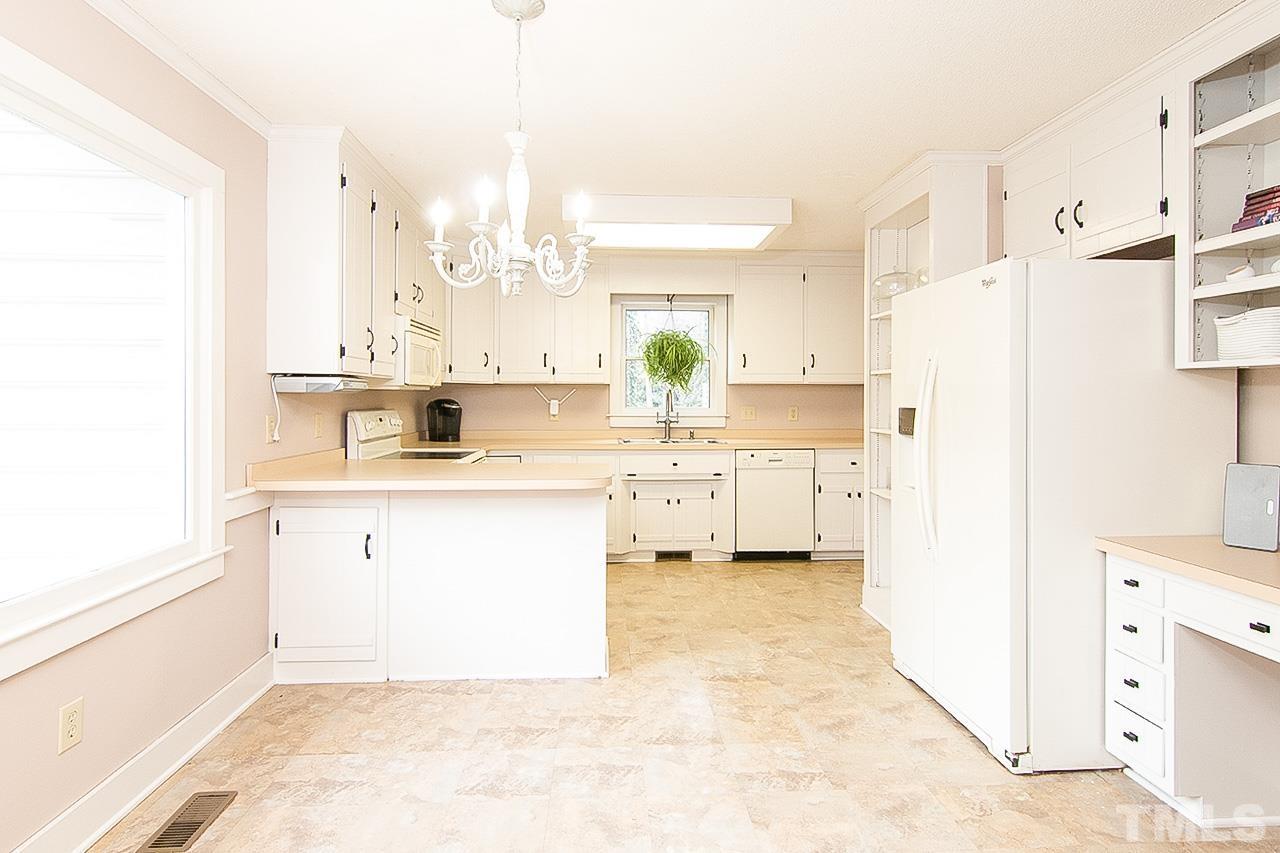 7300 Quinby Court Raleigh, NC 27613 - Photo 12 of 29 a kitchen with white cabinets and white appliances