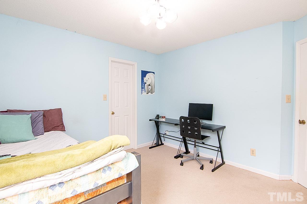 7300 Quinby Court Raleigh, NC 27613 - Photo 19 of 29 a bedroom with a bed a desk and chair